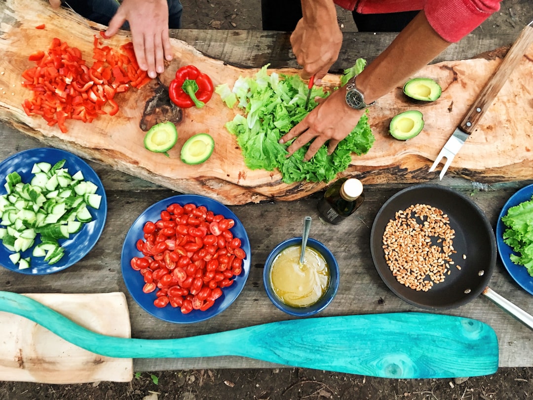 Home Person Slicing Green Vegetable In Front Of Round Ceramic Plates With Assorted Sliced Vegetables During Daytime Ezh46xcdqry